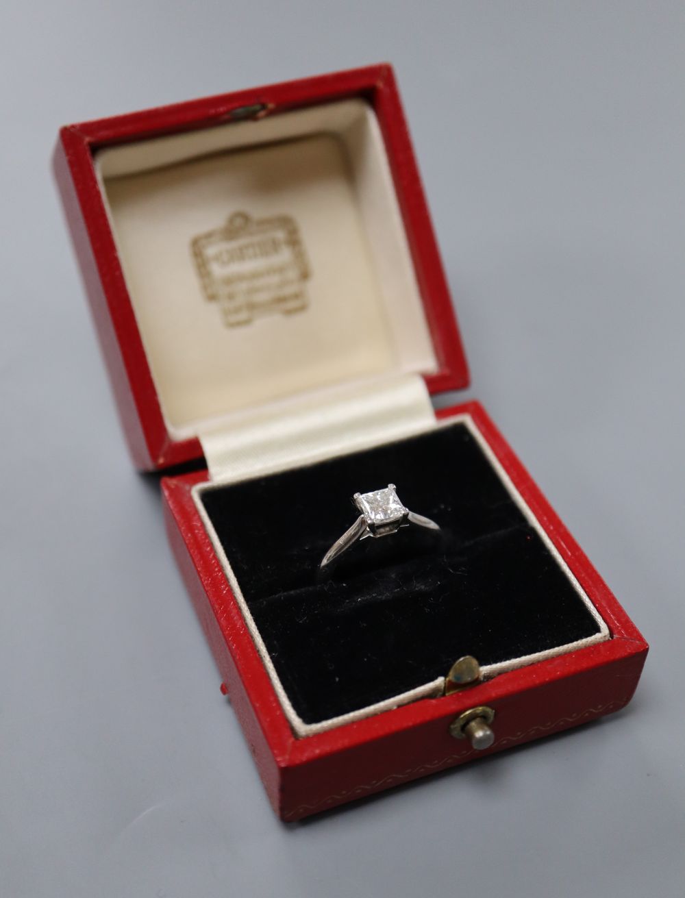 A modern Cartier platinum and Princess cut solitaire diamond ring,
